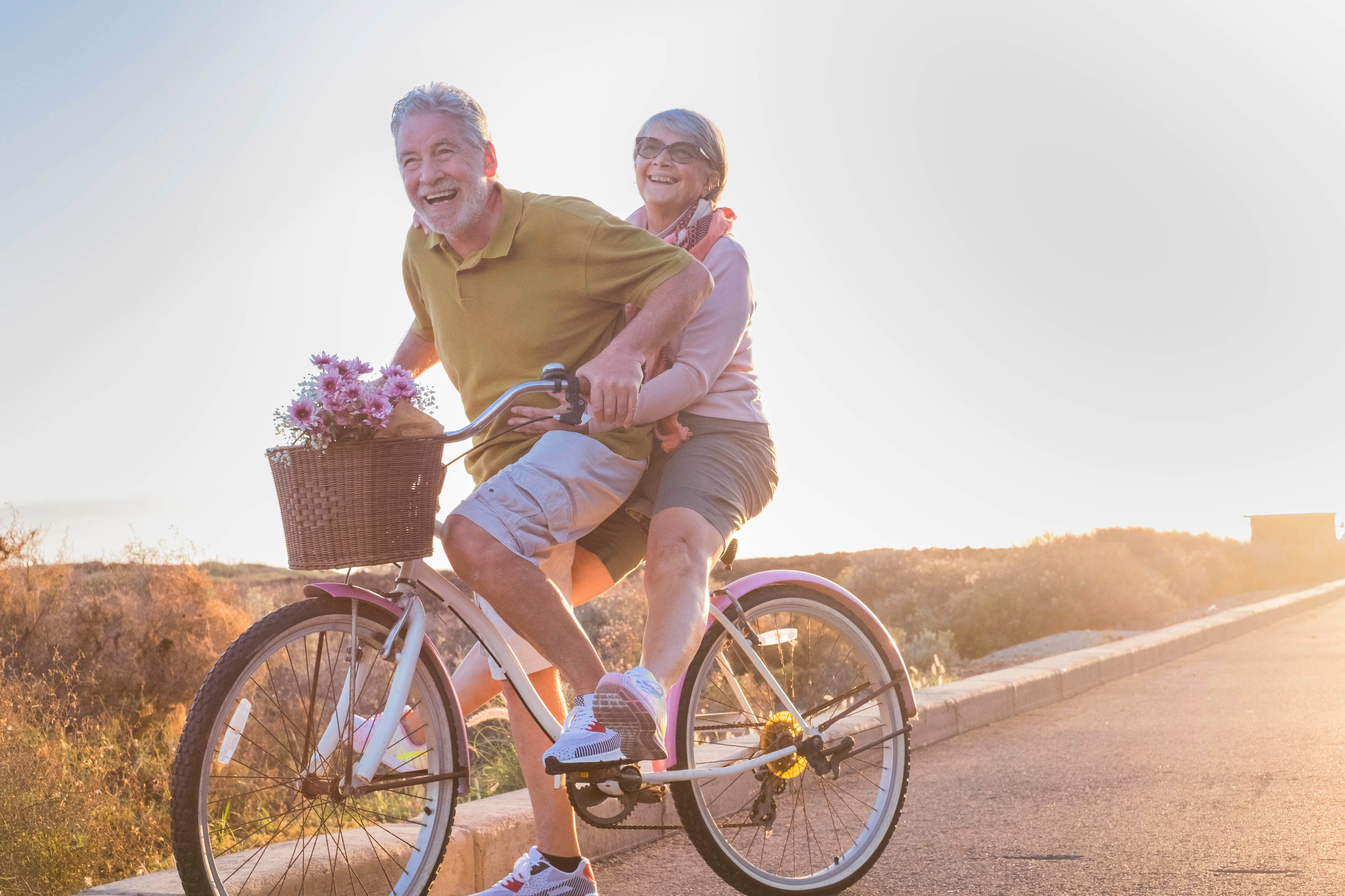 An older couple biking together out in the summer sunshine